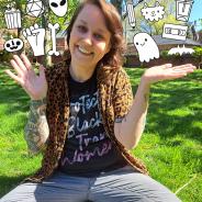 Andy sitting in a grassy area with black and white doodles floating in the air around them